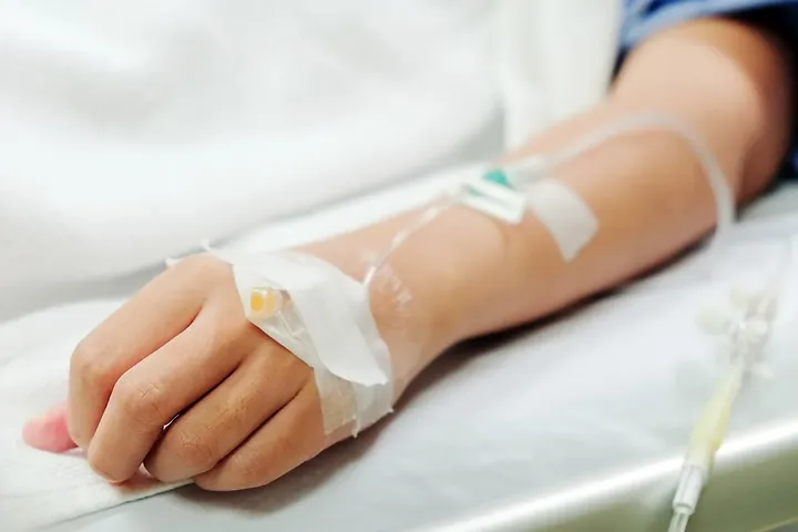 Patient hand with IV line iron infusion