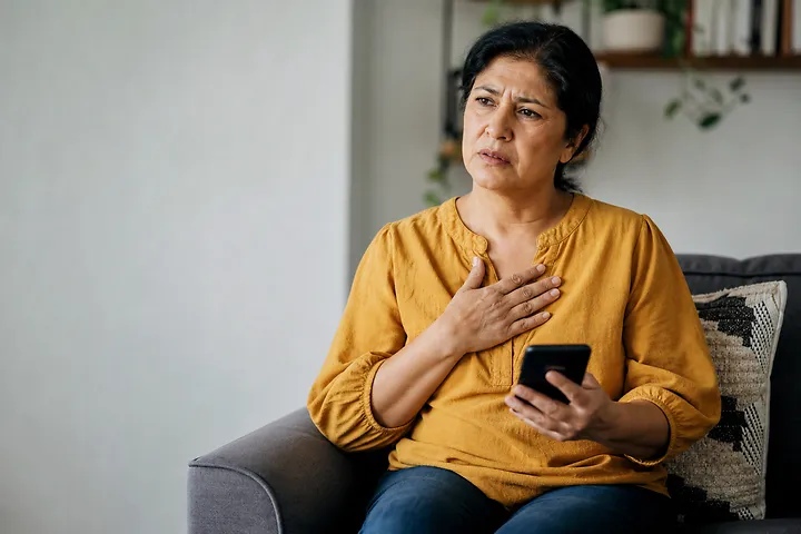 Woman clutching chest showing medical symptoms