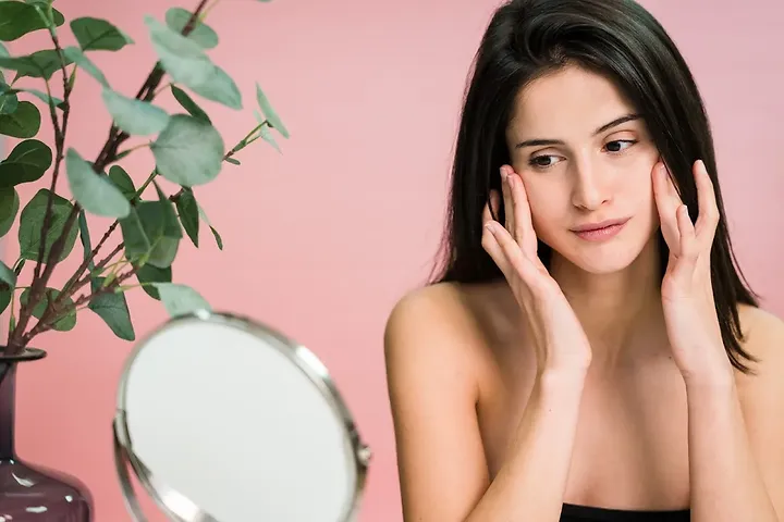 Woman checking skin for iron deficiency signs